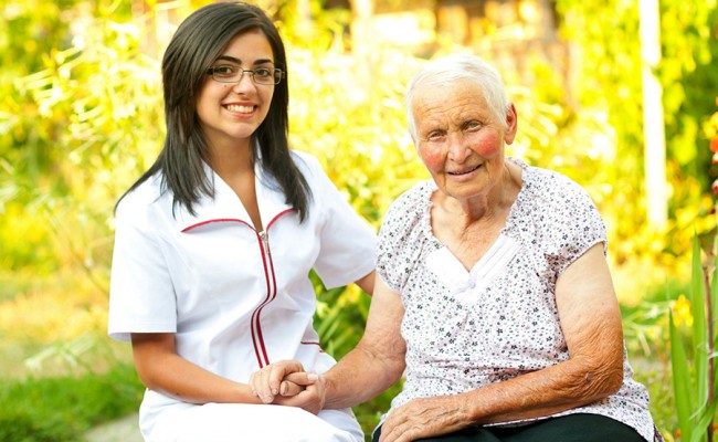 Caring doctor with happy elderly lady